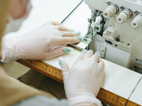 person sewing fabric with a sewing machine
